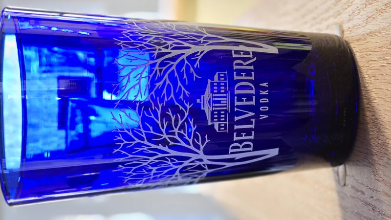 Vodka bottle etched with a fine tree design, lit from within by blue light