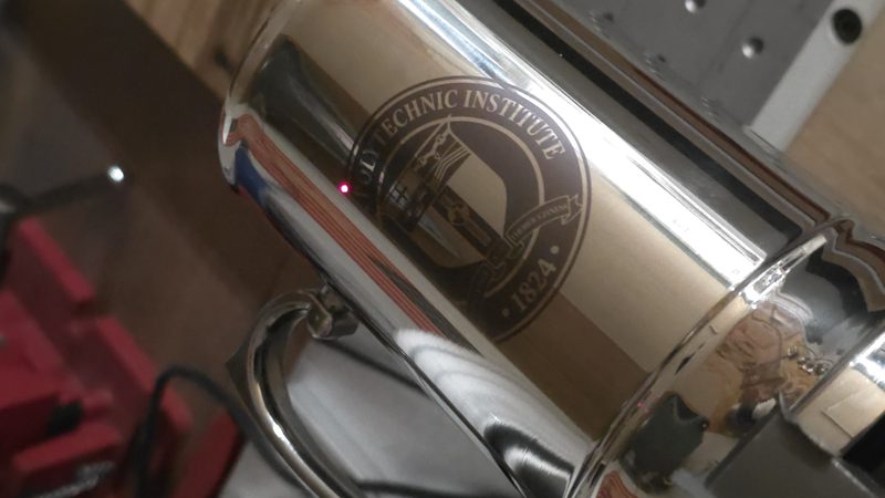 Stainless tumbler engraved with an institute crest, mounted under the laser