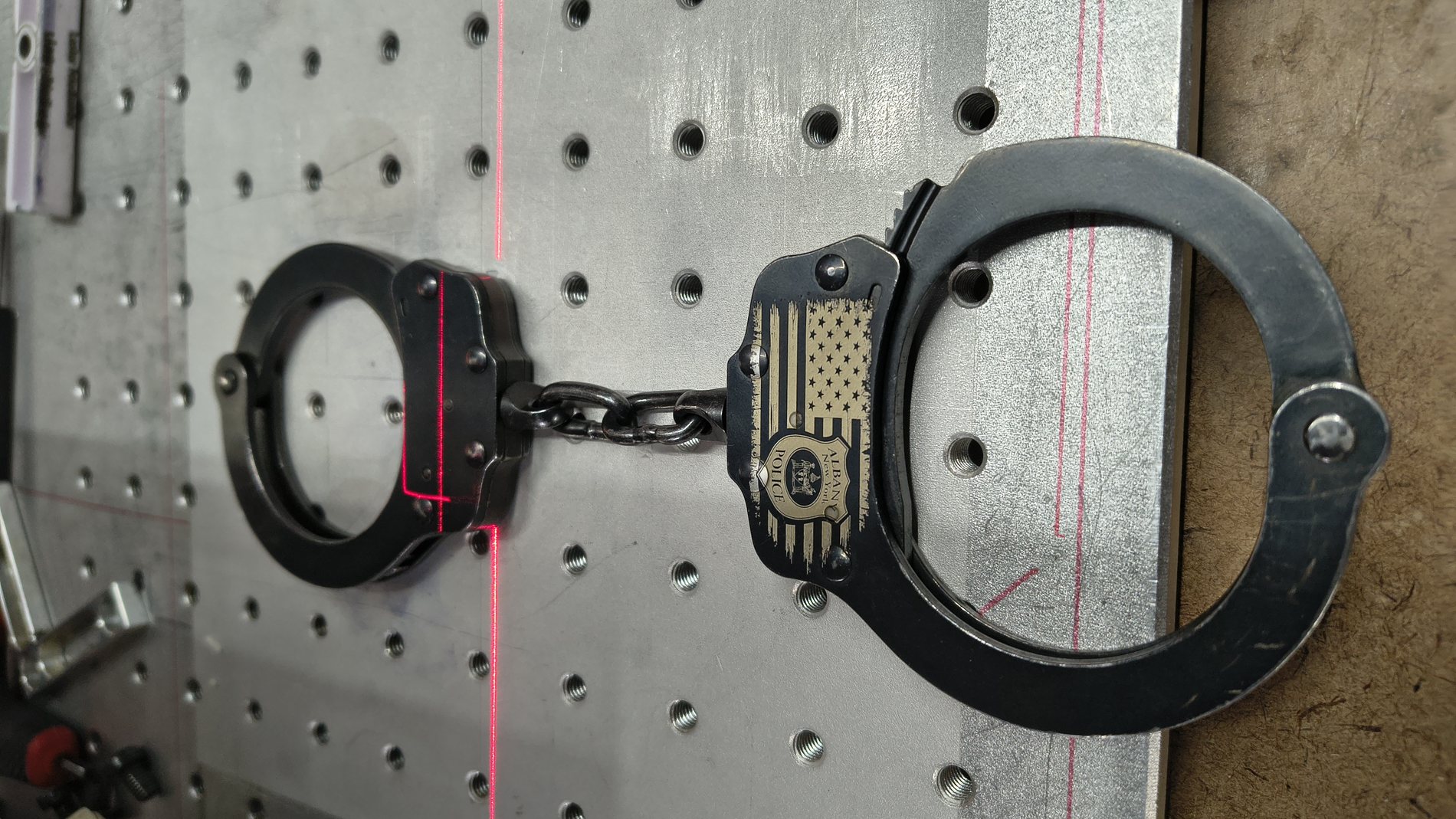 Steel handcuffs being laser engraved with a personalized marking