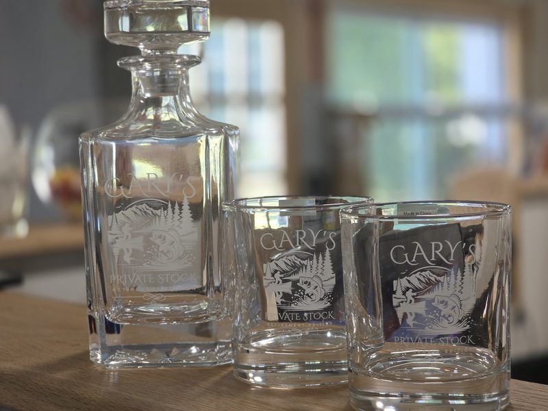 Etched crystal decanter and matching rocks glasses engraved with a mountain and lake scene